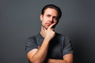 Gri arka planda genç adam portresi