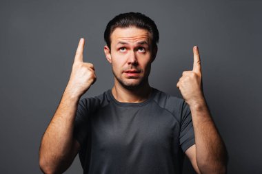 Gri arkaplanda portresi olan genç bir adam.