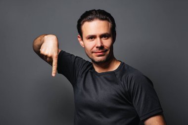 Gülümseyen genç adam, gri arka planda portresi var.