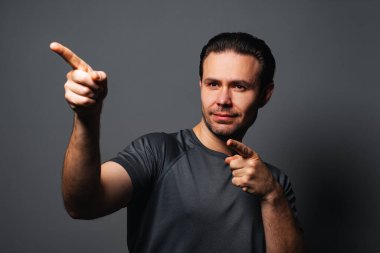 Yan tarafı gösteren başarılı genç adam, gri arkaplanda portre
