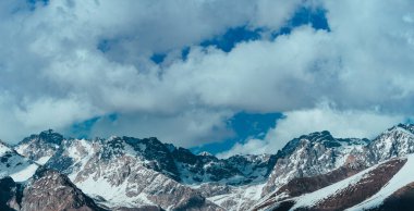 Karlı dağlar ve bulutlu panoramik manzara
