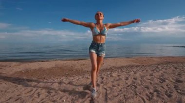 Yaz günü genç fitness kadını gölde koşuyor ve zıplıyor, ağır çekimde.