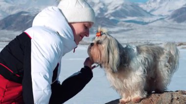 Kış günü Shih-tzu köpeği olan genç bir turistin portresi.