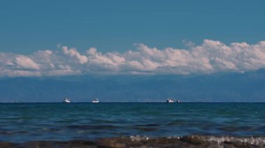 Issyk-Kul Gölü 'nde yaz mevsiminde yüksek dağlar ve gemilerle Kırgızistan