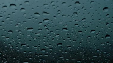 Pencerenin soyut arka planına yağmur damlaları yağar