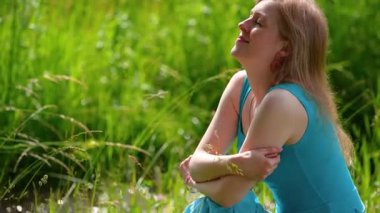 Düşünceli romantik kadın yaz otlağında oturuyor.