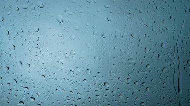 Pencerenin soyut arka planına yağmur damlaları yağar