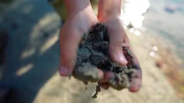 Çocuk elleri, saf dağ nehri arka planında doğal toprak.