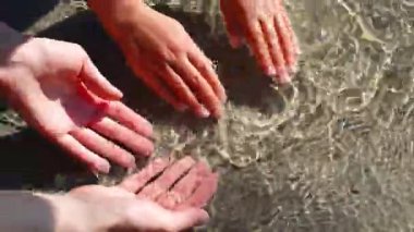 Anne ve çocuk temiz dağ nehrinde ellerini yıkıyorlar.