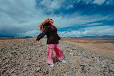 Genç kadın yaz günü dağlarda özgürlüğün tadını çıkarıyor.