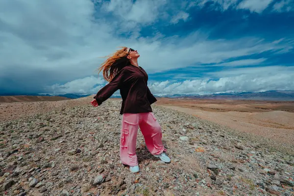 Genç kadın yaz günü dağlarda özgürlüğün tadını çıkarıyor.