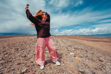 Genç kadın yaz günü dağlarda özgürlüğün tadını çıkarıyor.