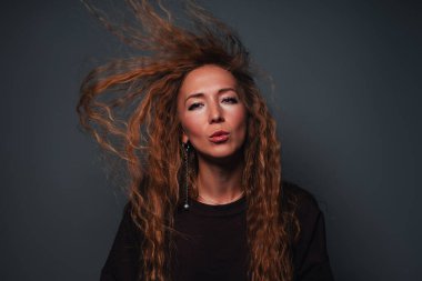 Genç ve güzel bir kadın dalgalı saçlarıyla stüdyo moda portresiyle