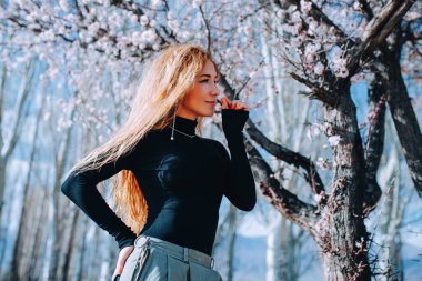 Ağacın altında çiçek kokan kadının romantik portresi.