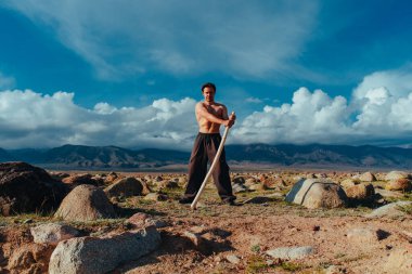 Güçlü bir adam yüksek dağlarda duruyor.