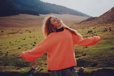 Genç, güzel, gülümseyen bir kadın. Sıcak, güneşli bir portre. Yaz günü dağlarda.