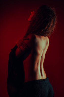 Sırtı çıplak, zarif, koyu renkli genç bir kadın.