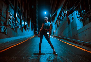 Seul 'deki modern gece caddesinde poz veren zayıf genç bir kadın.