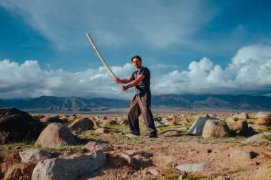 Yüksek dağlarda sopa eğitimi almış yakışıklı, güçlü bir adam.