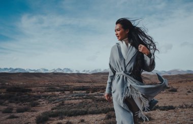Genç, güzel Asyalı bir kadın sonbahar günü dağlarda yürüyor.