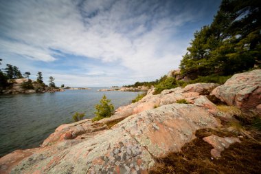 Killarney Provincial Park, Ontario, Kanada 'daki göl boyunca uzanan Büyük Kırmızı Granit Kaya Sahil Hattı manzaralı dramatik bir manzaraydı.