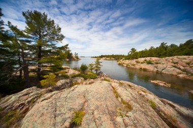 Killarney Provincial Park, Ontario, Kanada 'daki göl boyunca uzanan Büyük Kırmızı Granit Kaya Sahil Hattı manzaralı dramatik bir manzaraydı.