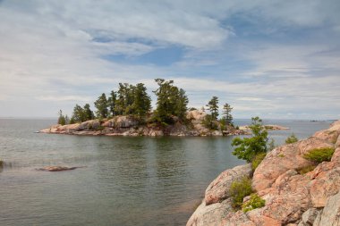Killarney Provincial Park, Ontario, Kanada 'da göl boyunca uzanan Red Granite Rock Shoreline manzarası
