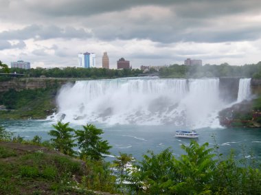 Ontario, Kanada - 22 AĞUSTOS 2018: Gri Dusky Günü 'nde Niagara Şelalesi' nin Kanadalı manzaralı, Atnalı Şelalesi 'nin sisli sisinde seyyar turist gezisi teknesi