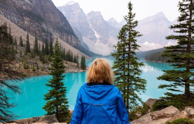 Alberta, Kanada - 4 AUGust 2021: Yalnız Kadın Gezgin Hiker Turist Moraine Gölü Dramatik Vista 'yı gözlemledi