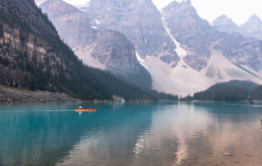 Alberta, Kanada - 4 AUGust 2021: Turuncu Teknede Dişi Kürekçiler, Moraine Gölü 'nün Su Aynası, Banff Ulusal Parkı, Alberta, Kanada