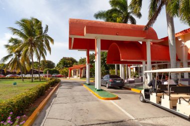 Cayo Guillermo, Küba - 7 Ağustos 2016: Golf arabasında çatı katlı otel girişinde misafir bekleyen otel görevlileri, sıcak, güneşli tropikal bir gün