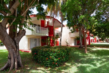 Cayo Guillermo, Küba - 7 Ağustos 2016: Yeşil ağaçlar ve çalılarla çevrili rahat kulübeler tropik tatil beldesi misafirlerini kabul etmeye hazır, sıcak, güneşli tropikal bir gün