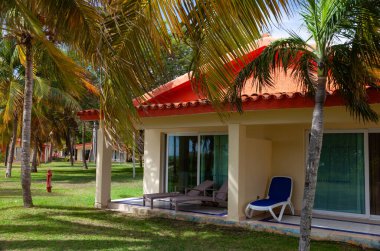 Cayo Guillermo, Küba - 7 Ağustos 2016: Yeşil ağaçlar ve çalılarla çevrili rahat kulübeler tropik tatil beldesi misafirlerini kabul etmeye hazır, sıcak, güneşli tropikal bir gün