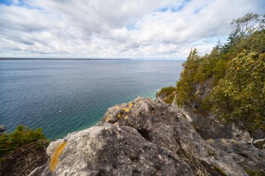 Huron Gölü 'nün Turkuaz Suyu ile çevrili Rocky Kireçtaşı Uçurumu. Hindistan yakınlarındaki Fırtınalı Sonbahar Günü Ontario, Kanada 