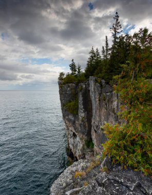 Huron Gölü 'nün Turkuaz Suyu ile çevrili Kireçtaşı Duvarlı Uçurum, Ontario, Kanada' daki Indian Head Trail 'de fırtınalı bir sonbahar gününde dikey çekim. 