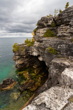 Huron Gölü 'nün Turkuaz Suyu ile çevrili Grotto Mağara Girişi ile Engebeli Kayalık. Hindistan 'da Fırtınalı Sonbahar Günü, Ontario, Kanada 