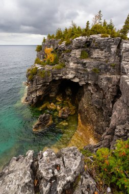 Huron Gölü 'nün Turkuaz Suyu ile çevrili Grotto Mağara Girişi ile Engebeli Kayalık. Hindistan 'da Fırtınalı Sonbahar Günü, Ontario, Kanada 