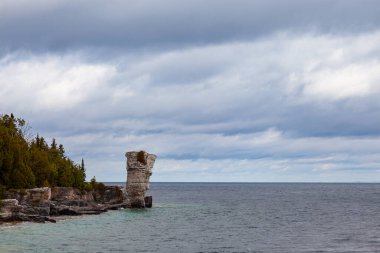 Vase Shape Limestone Rock Formation standing on Lake Huron Georgian Bay Coast. Flowerpot Island of Fathom Five National Marine Park, Autumn Stormy Day, Ontario, Canada clipart