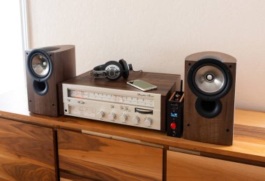 Hoparlörlü ve kulaklıklı, Wooden Retro Rafına yerleştirilmiş ev yapımı Stereo Alıcı. Smartphone: Kaynak, Yeni ve Eski Teknoloji Birlikte Çalışıyor.