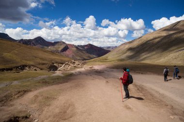 Gökkuşağı Dağı, Peru - 12 Mayıs 2018: Kamp Yolundaki Gökkuşağı Dağından inen Turist Yürüyüşçüleri. Vinicunca Park 'ta güneşli bir bahar günü, Peru, Real Colours
