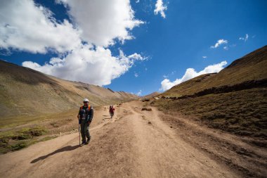 Gökkuşağı Dağı, Peru - 12 Mayıs 2018: Kamp Yolundaki Gökkuşağı Dağından inen Turist Yürüyüşçüleri. Vinicunca Park 'ta güneşli bir bahar günü, Peru, Real Colours