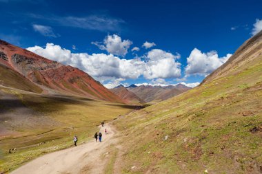 Gökkuşağı Dağı, Peru - 12 Mayıs 2018: Kamp Yolundaki Gökkuşağı Dağından inen Turist Yürüyüşçüleri. Vinicunca Park 'ta güneşli bir bahar günü, Peru, Real Colours