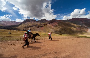 Gökkuşağı Dağı, Peru - 12 Mayıs 2018: Geleneksel Giysiler Giyen Yerli Perulu Adam Patikada Turist At Sürücüleri Grubu 'na liderlik ediyor. Vinicunca Park, Peru 'da güneşli bir bahar günü