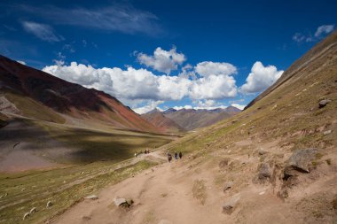 Gökkuşağı Dağı, Peru - 12 Mayıs 2018: Kamp Yolundaki Gökkuşağı Dağından inen Turist Yürüyüşçüleri. Vinicunca Park 'ta güneşli bir bahar günü, Peru, Real Colours