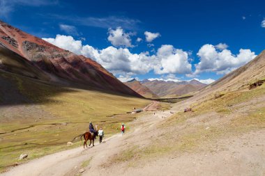 Gökkuşağı Dağı, Peru - 12 Mayıs 2018: Kamp Yolundaki Gökkuşağı Dağından inen Turist Yürüyüşçüleri. Vinicunca Park 'ta güneşli bir bahar günü, Peru, Real Colours