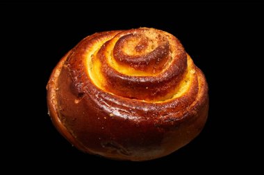 Image of a twisted bun with sugar on a black background