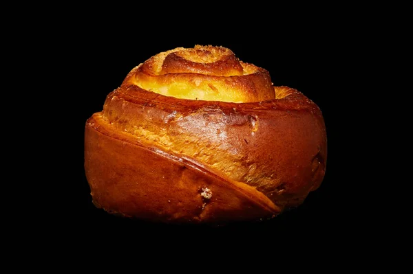 Image of a twisted bun with sugar on a black background