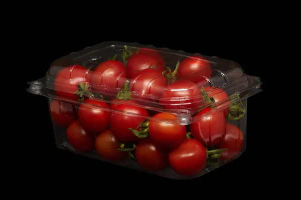 Image of small tomatoes in plastic packaging on a black background