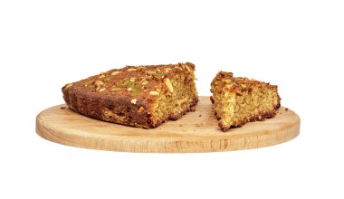 Image of several pieces of homemade sponge cake with nuts on a wooden cutting boar