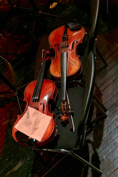在中间休息的时候 交响乐团的两把小提琴放在椅子上 — 图库照片